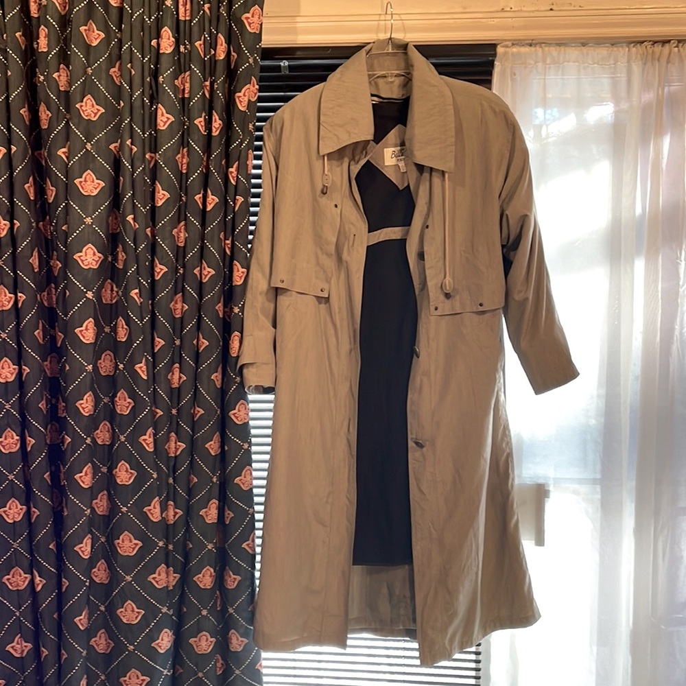 Women’s full length trench coat with waist belt.